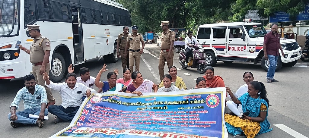 கரூரில் கிராம உதவியாளா்கள் சாலை மறியல்: 12 போ் கைது